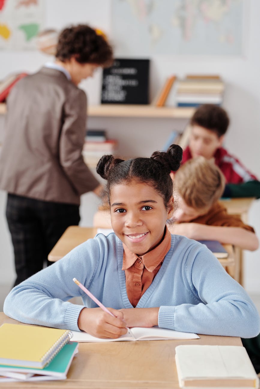 girl in blue long sleeve shirt holding pen